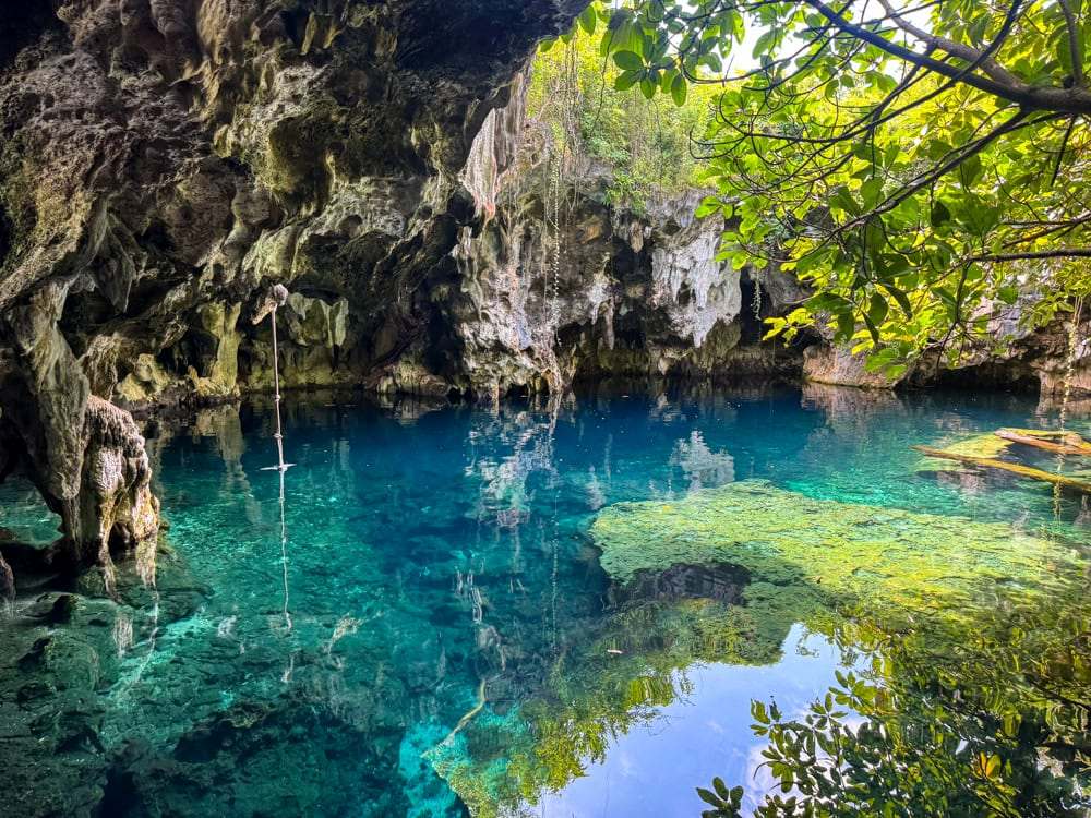 Swimmers in the crystal clear blue water of Maalum Cave